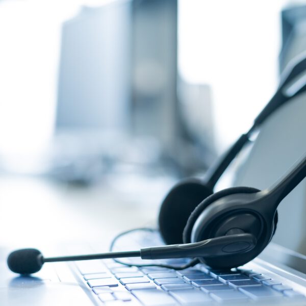Nahaufnahme eines Headsets auf einem Laptop. Helpdesk. Arbeitsplatz eines Support-Service-Mitarbeiters.